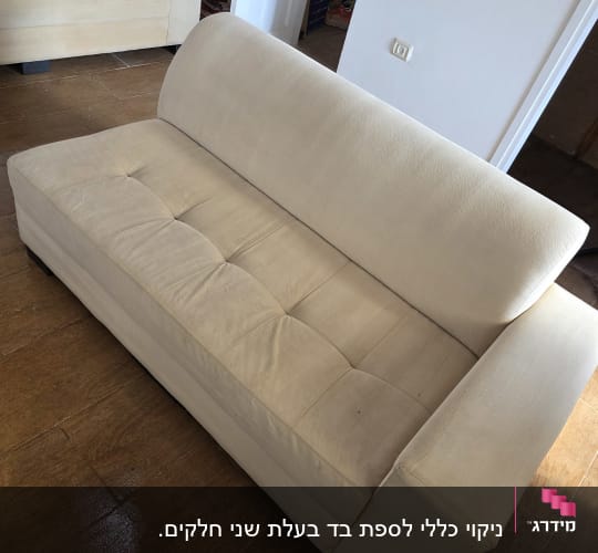 ספה נקייה בחדר עם רצפת עץ